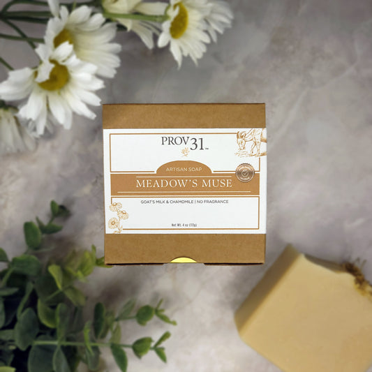 PROV 31 goat milk artisan soap on marble with packaging and plants in background.